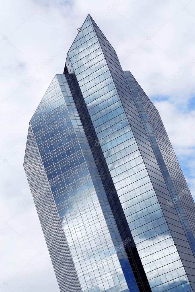 Corporate building with glass walls reflecting clouds