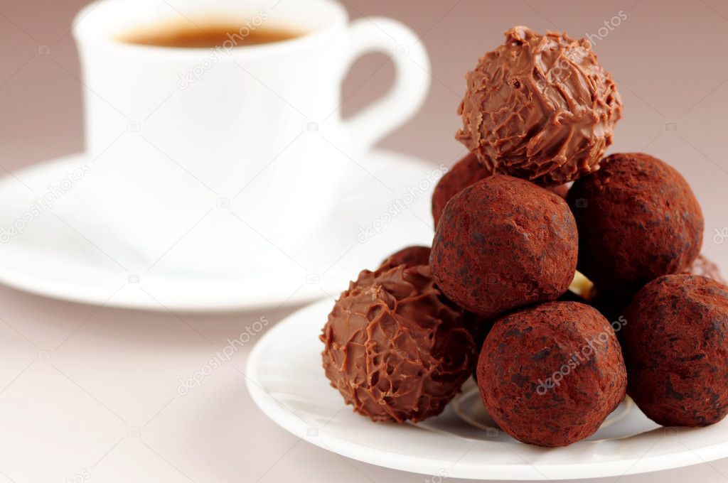 Gourmet chocolate truffles on a plate with a cup of coffee