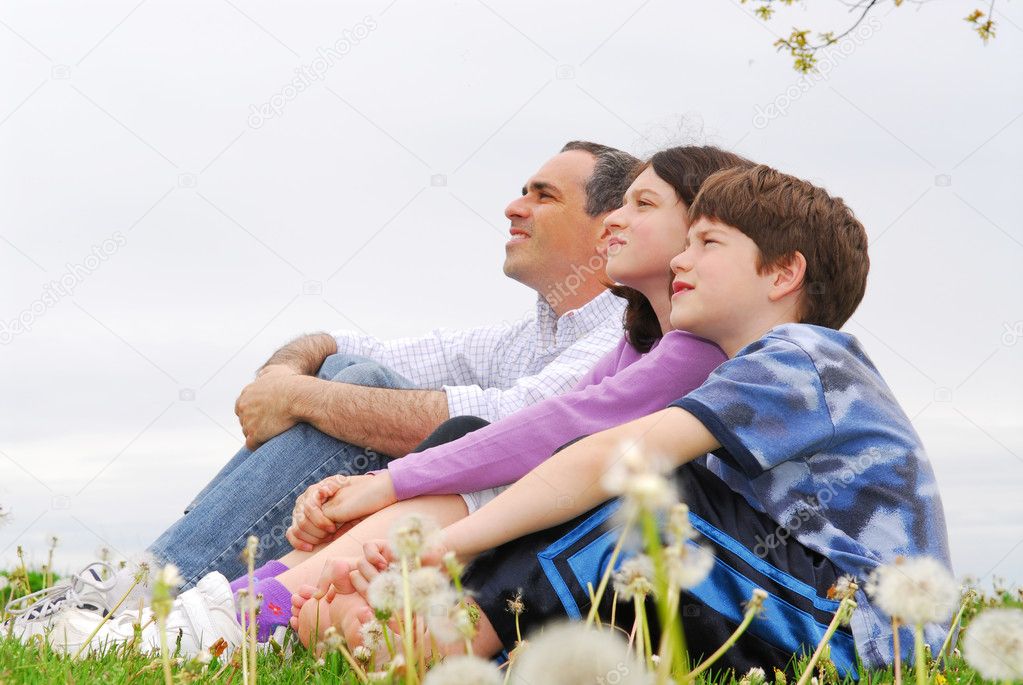 Portrait of a family father and children outside on green grass