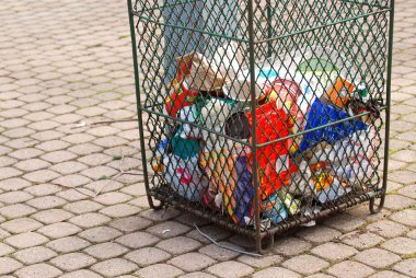 Metal mesh garbage bin in a city park clipart