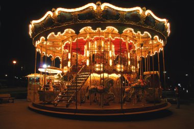 Brightly illuminated traditional carousel in Paris France at night clipart