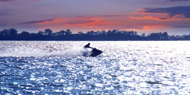 Man on jet ski at sunset