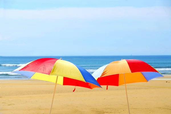 Δύο Παραλία Ubrella Στέκεται Στην Όχθη Του Ωκεανού — Φωτογραφία Αρχείου