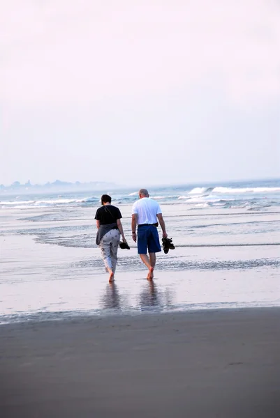 中高年カップル 砂浜のビーチの上を歩いて — ストック写真