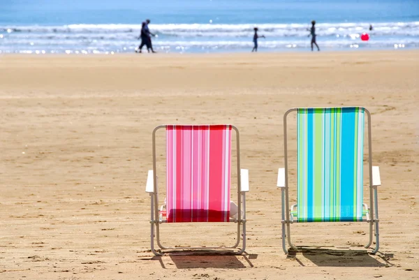 砂浜のビーチでの つの空のカラフルなビーチ椅子 — ストック写真