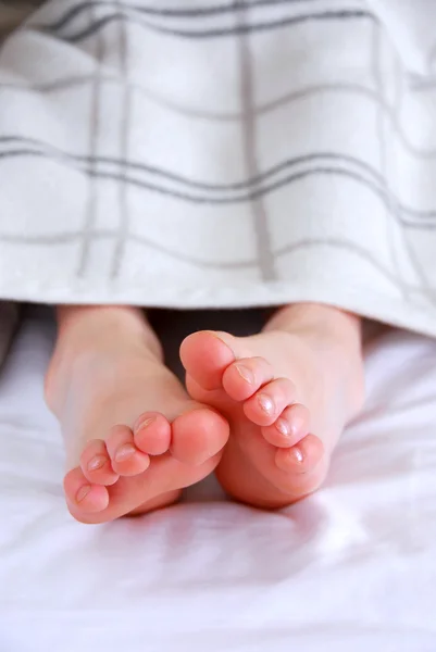 Πόδια Του Παιδιού Που Βγαίνει Από Μια Κουβέρτα Ένα Κρεβάτι — Φωτογραφία Αρχείου