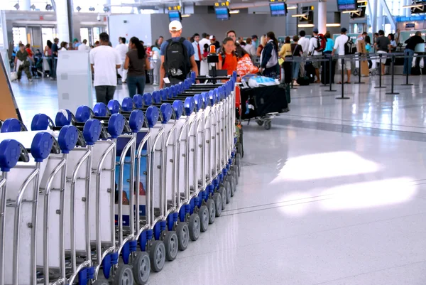 近代的な国際空港でのチェックイン カウンターで並んで乗客 — ストック写真