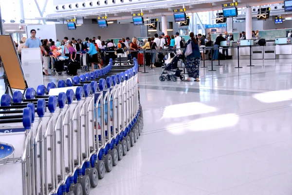近代的な国際空港でのチェックイン カウンターで並んで乗客 — ストック写真