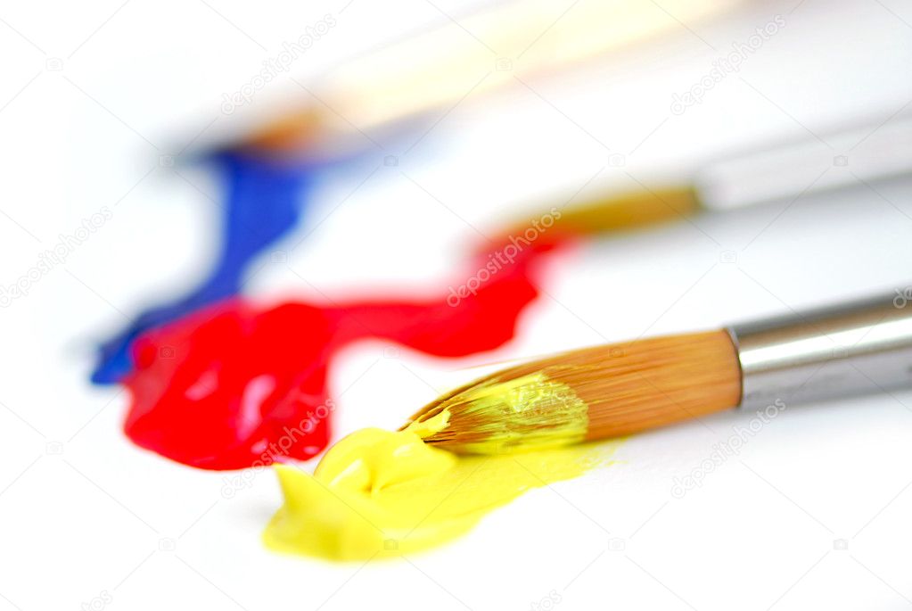 Macro of paintbrushes with paint of primary colors