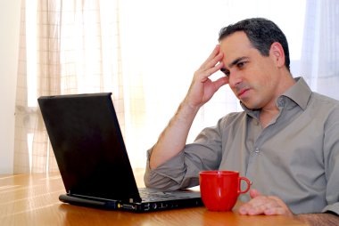 Man sitting at a desk and looking into his computer clipart