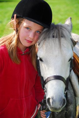 Portrait of a young girl with a white pony clipart