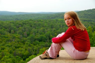 Young girl sitting on an edge of a cliff clipart