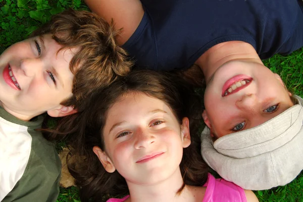 Portret Trzech Młodych Dzieci Leżąc Trawie Patrząc — Zdjęcie stockowe