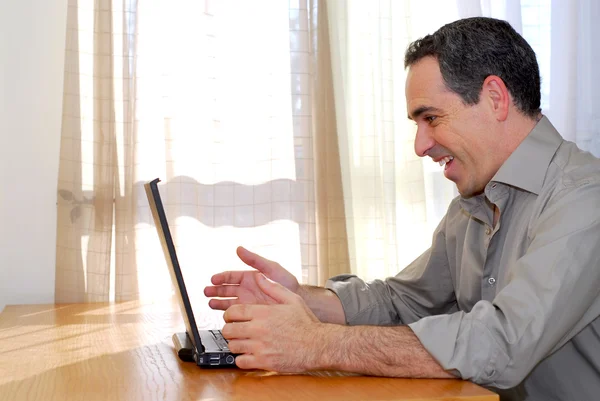 Homem Sentado Uma Mesa Olhando Para Seu Computador Mostrando Felicidade — Fotografia de Stock