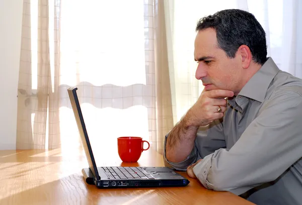 Mężczyzna Siedzący Przy Biurku Patrząc Jego Komputerze — Zdjęcie stockowe
