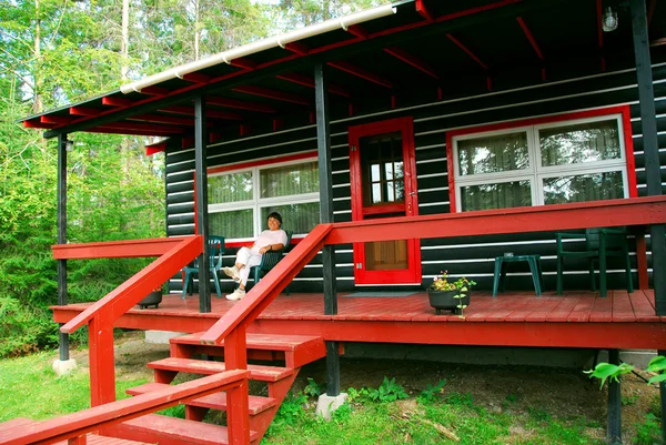 Frau Sitzt Auf Einem Deck Der Blockhütte — Stockfoto