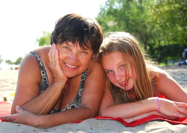 祖母と孫娘 砂浜のビーチの上に横たわるの肖像画 — ストック写真