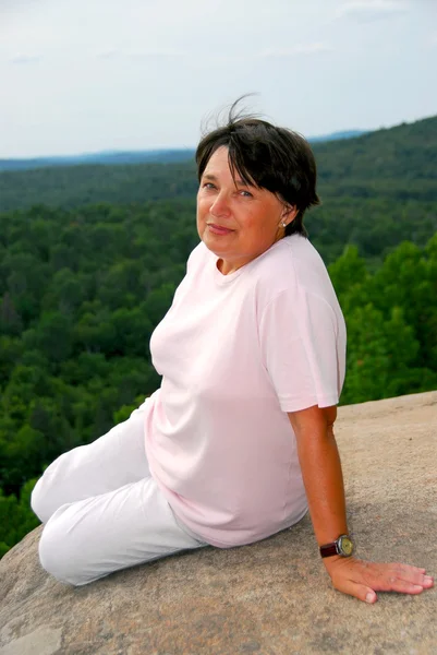 風光明媚な崖の端に座っている熟女 — ストック写真