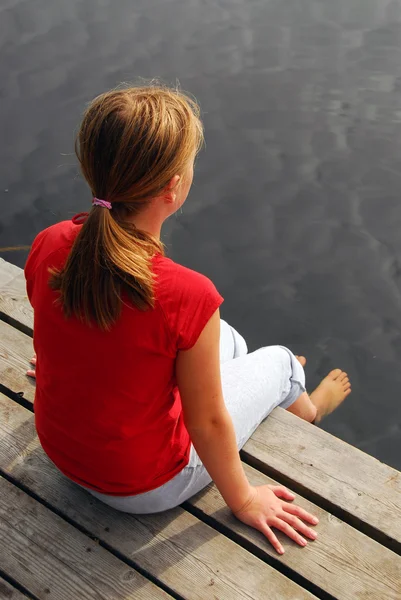 木製のボートのドックから湖の足を浸漬の若い女の子 — ストック写真