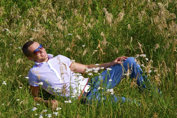 Šťastný mladý muž v trávě — Stock fotografie