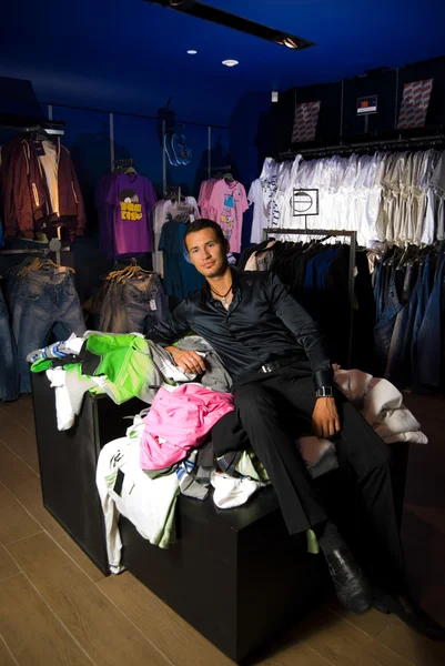 Junger erwachsener Mann im Kleiderladen — Stockfoto