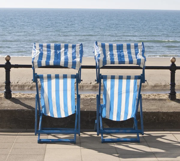 Lege ligstoelen kijkt uit over de zee — Stockfoto
