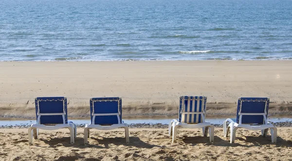 Four blue reclining sun loungers over looking the sea — Stock Photo, Image