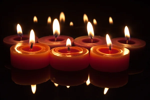Red candles with flames on a dark background — Stock Photo, Image