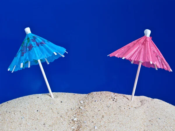 Coctail umbrellas in the sand — Stock Photo, Image
