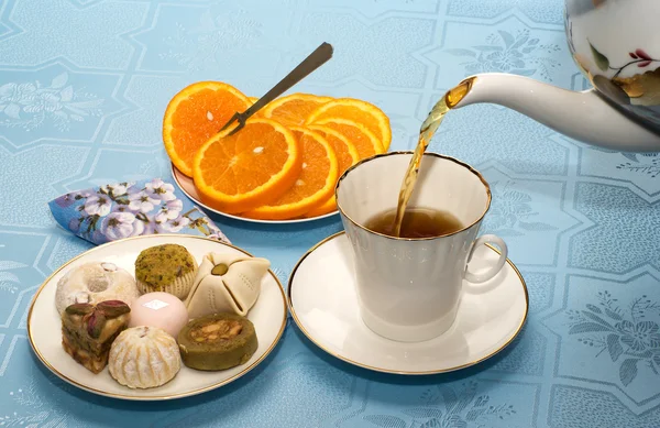 Bule, xícara de chá e bolos — Fotografia de Stock