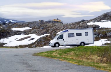 Caravan van on high-mountainous road of Norway clipart