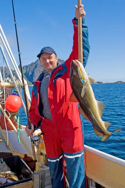 Pescatore con il pesce grosso e la filatura Fotografia Stock