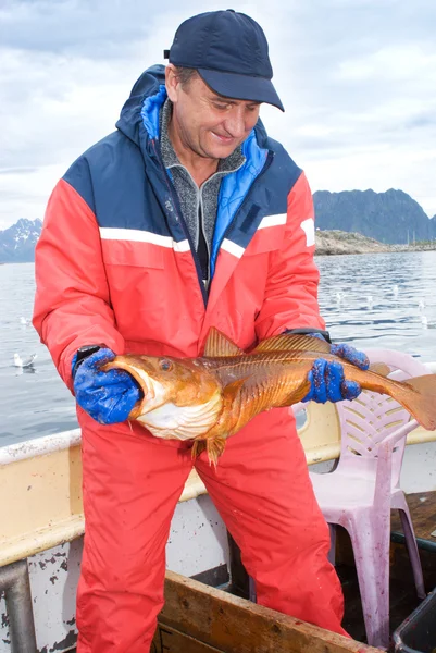 Fiskare med stor fisk på båten — Stockfoto