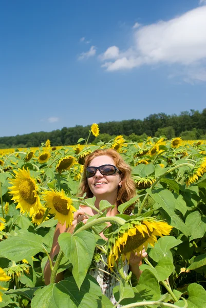 Die schöne Frau auf dem Feld der Sonnenblumen — Stockfoto