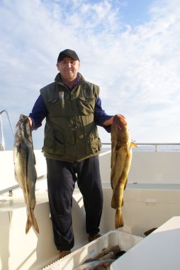 visser met grote vis op de boot