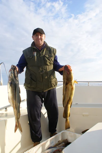Fiskare med stor fisk på båten — Stockfoto