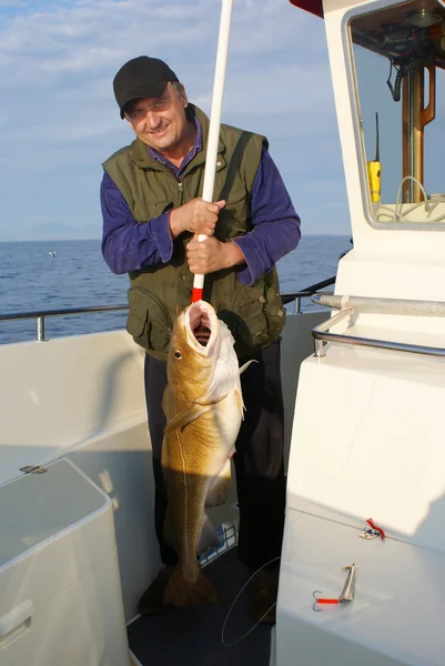 Pescador con peces muy grandes en el barco — Foto de Stock
