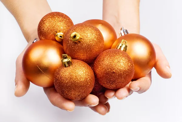 Női kéz a karácsonyi gömbök — Stock Fotó