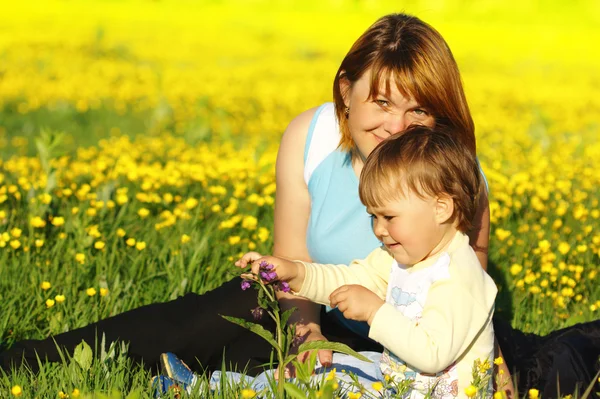 Mãe e seu filho brincam no prado — Fotografia de Stock