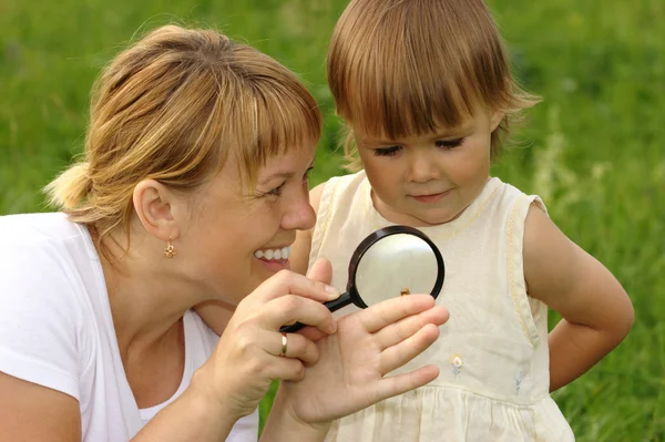 Criança com mãe olhando para caracol — Fotografia de Stock