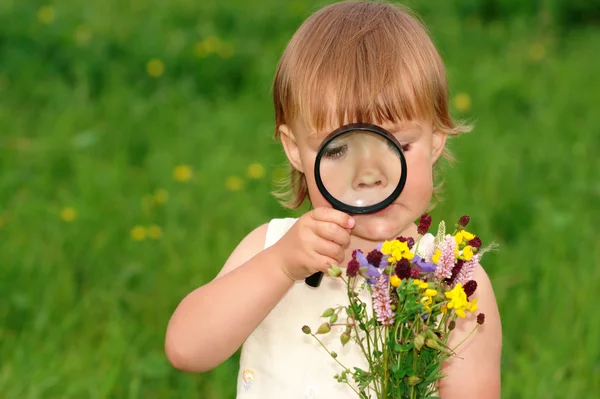 Niño está mirando las flores —  Fotos de Stock