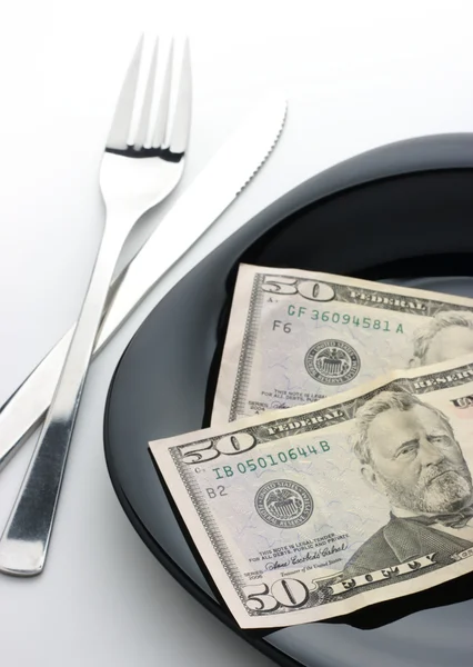Dolarů na desce s vidličkou a nožem — Stock fotografie