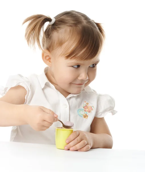 Маленькая девочка ест йогурт — стоковое фото