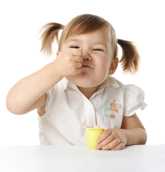 Funny little girl eats yogurt — Stock Photo, Image