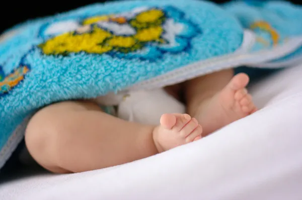 하얀 침대 시트에 유아의 발 — 스톡 사진