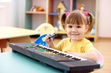 Elektronik piyano ile şirin çocuk
