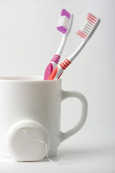 Dos cepillos de dientes y hilo dental —  Fotos de Stock