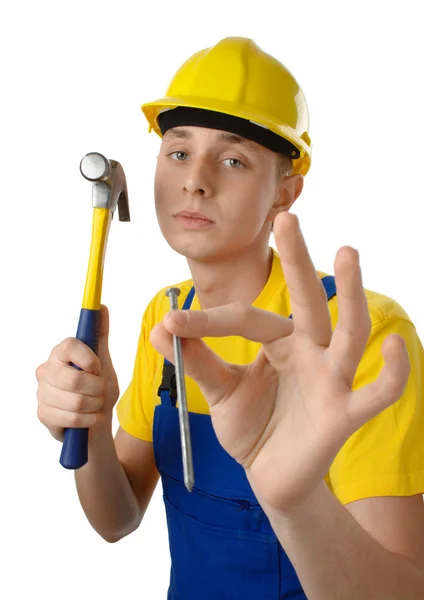 Jeune travailleur serein avec marteau et clou — Photo