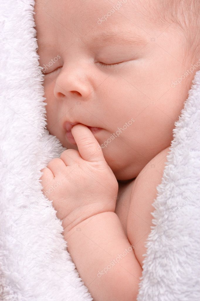 Cute newborn sleeps wrapped in blanket