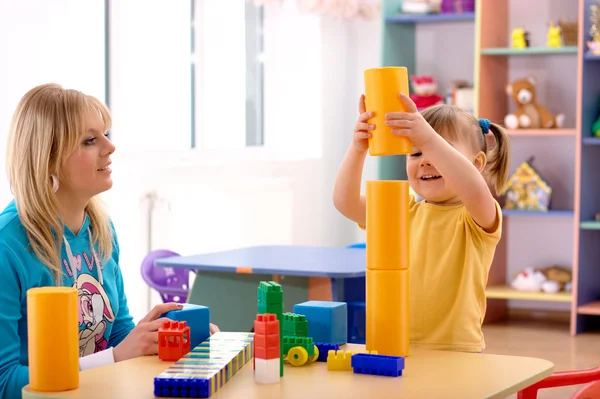 Teacher and preschooler play with building bricks — Stock Photo, Image